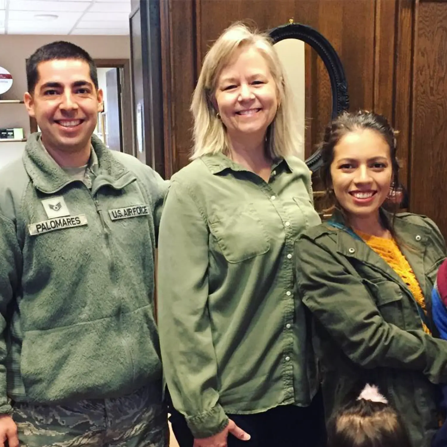 Mortgage broker Linda Love smiles with a U.S. Air Force service member and a woman, celebrating their home closing. They appear happy.